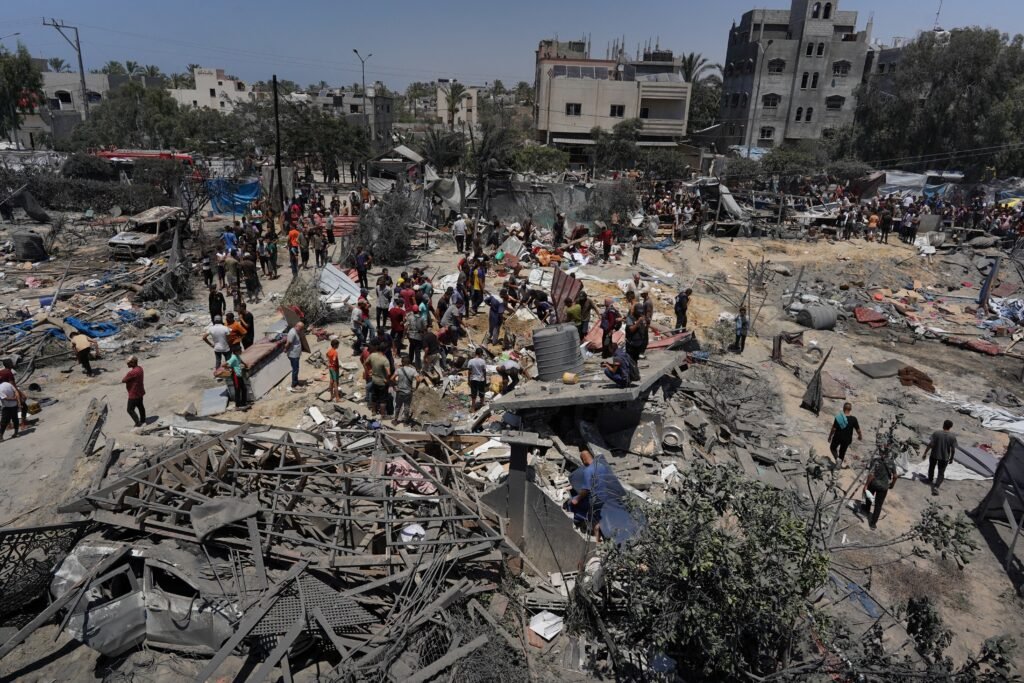 Palestinians look at the debris of destroyed tents and make shift housing structures following an Israeli military strike on the al-Mawasi camp for internally displaced people (IDP), near the city of Khan Yunis, southern Gaza Strip on July 13, 2024, in which 71 people were killed. - Al-Mawasi had been declared a safe zone by Israel as it pursues its military offensive in other parts of the Gaza Strip in response to the October 7 Hamas attacks. (Photo by Bashar TALEB / AFP)